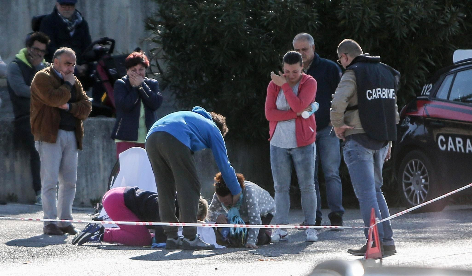 Varias personas, visiblemente afectadas, rodean el cuerpo sin vida de Michele Scarponi, atropellado en Filottrano.