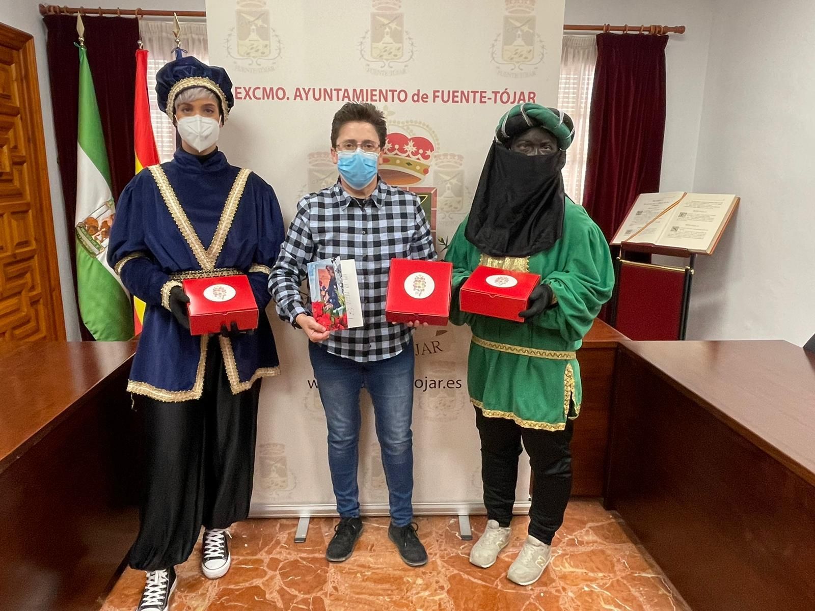 La alcaldesa, con los pajes reales, muestra el obsequio.