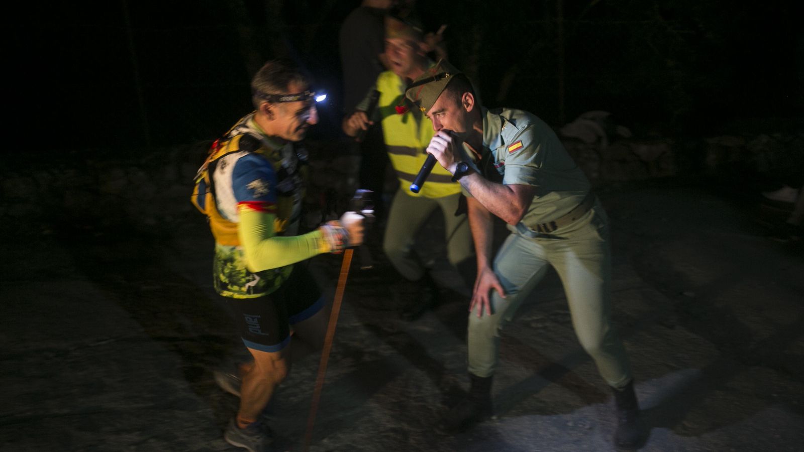 Legionarios animando en mitad de la noche junto a un punto de avituallamiento.