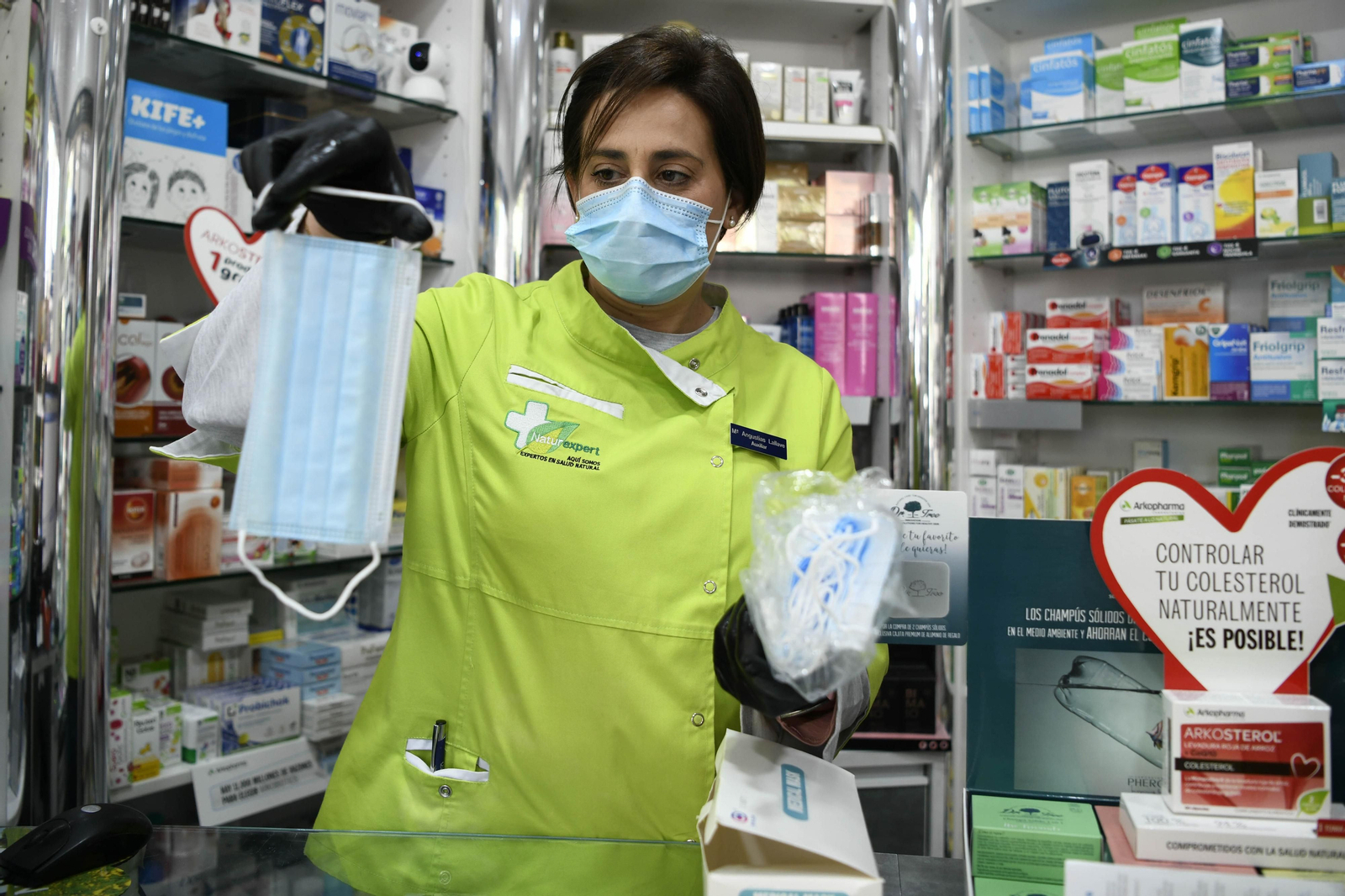 Una farmacéutica muestra mascarillas quirúrgicas.