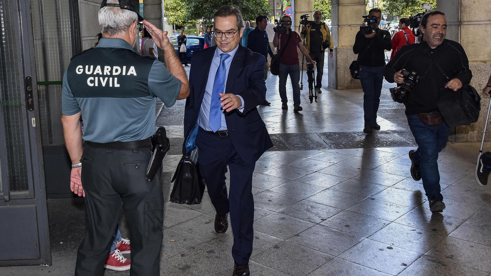 Un agente de la Guardia Civil saluda formalmente al juez de refuerzo José Ignacio Vilaplana, a su llegada a los juzgados de Sevilla.
