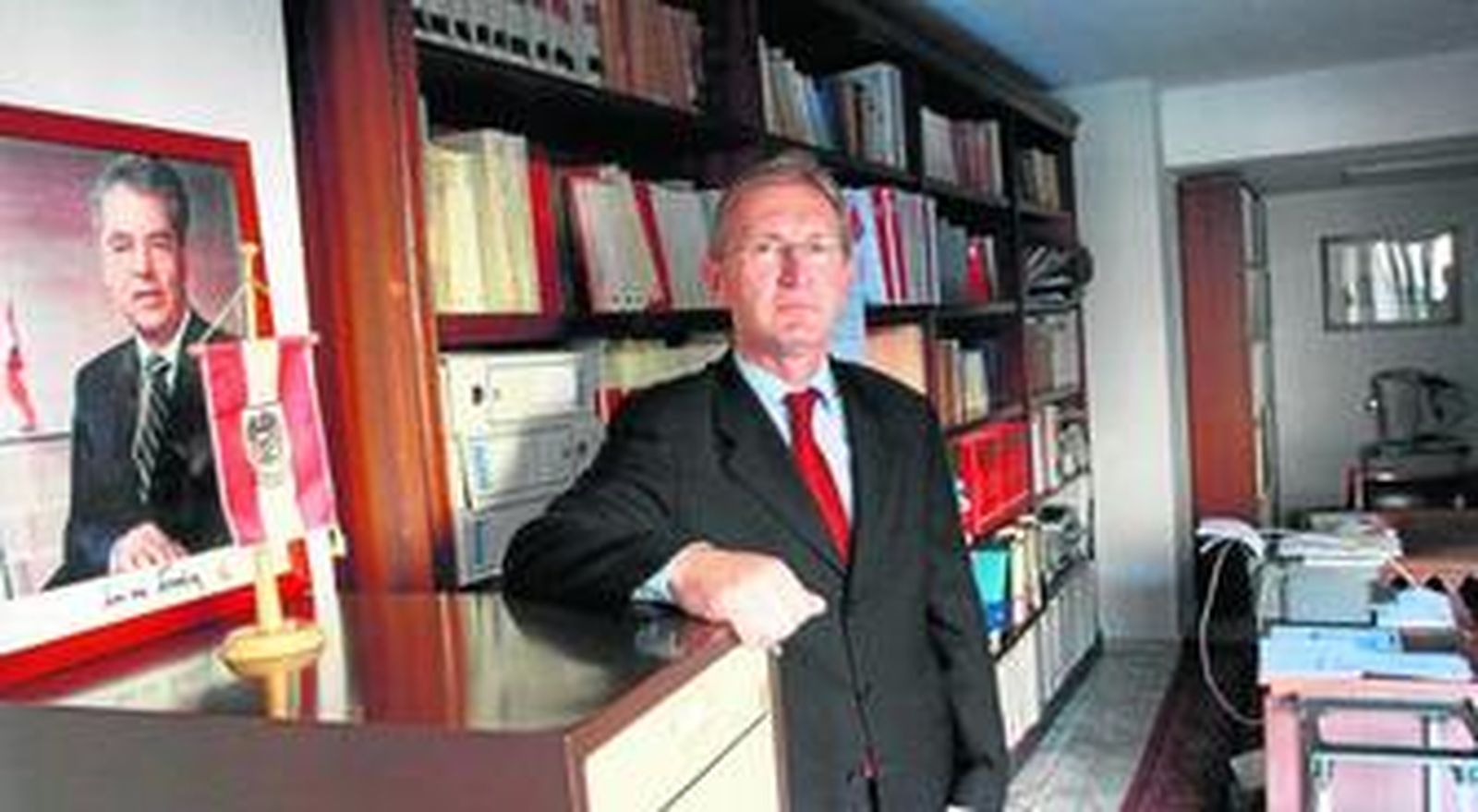 Ignacio Romero Boldt posa momentos después de la entrevista en el consulado de Austria en Málaga, junto a una bandera y la imagen del presidente de ese país.