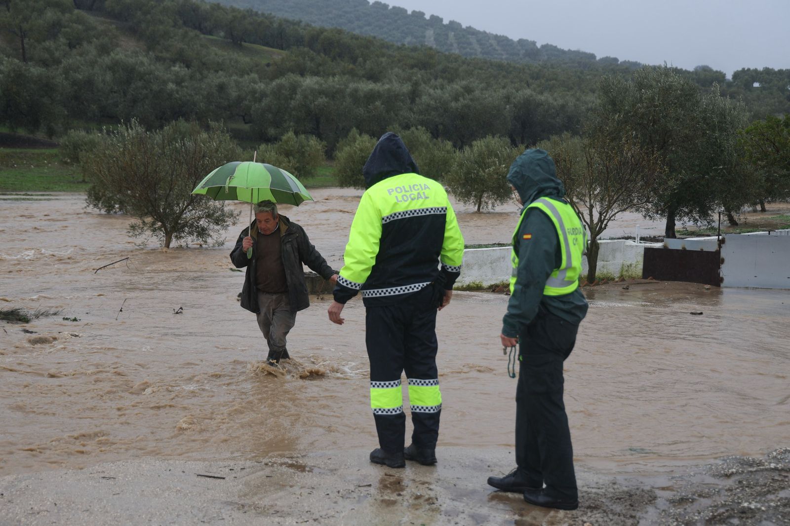La Policía Local ayuda a un vecino de Villanueva del Rosario, durante el temporal de lluvias de 'Leonardo'.