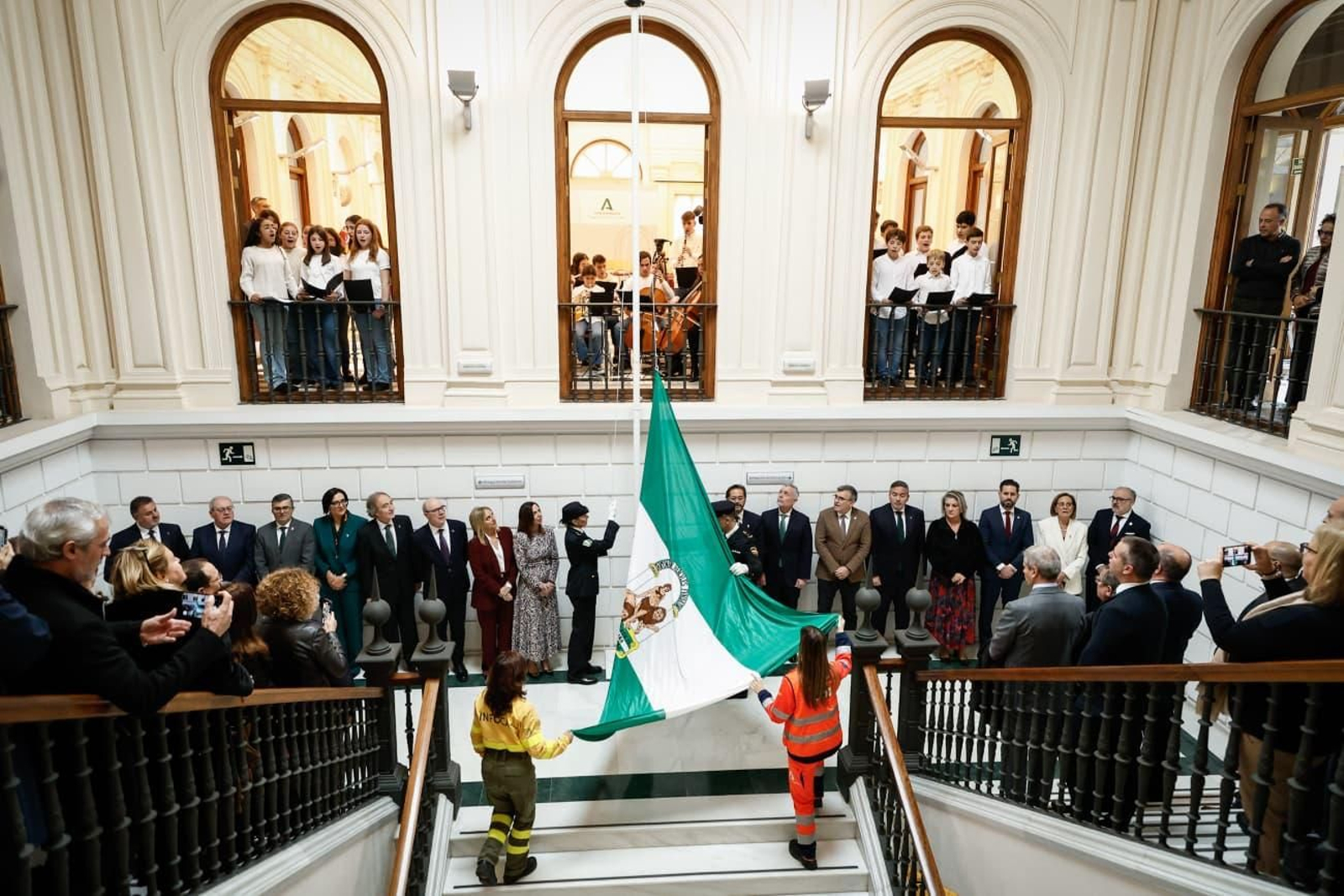 Un coro entona en himno de Andalucía en el momento del izado de la bandera en la Delegación de la Junta en Granada