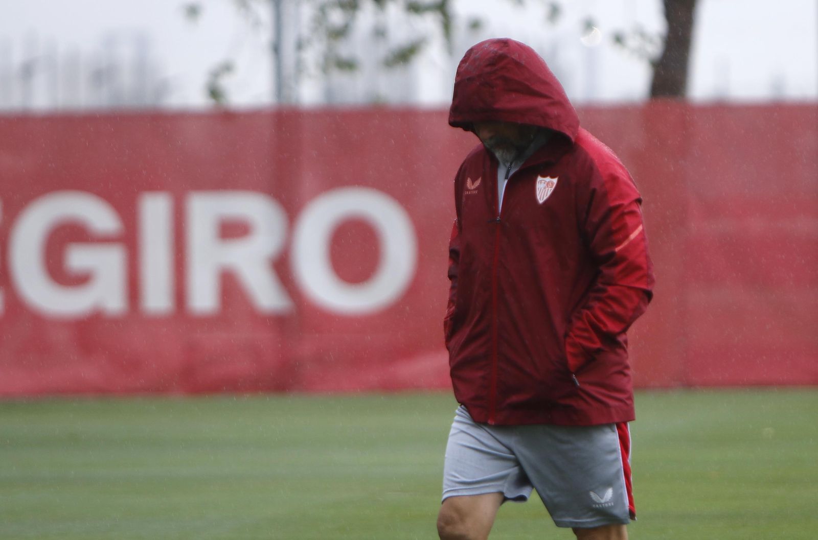 Sampaoli se resguarda de la lluvia bajo un chubasquero el pasado viernes.