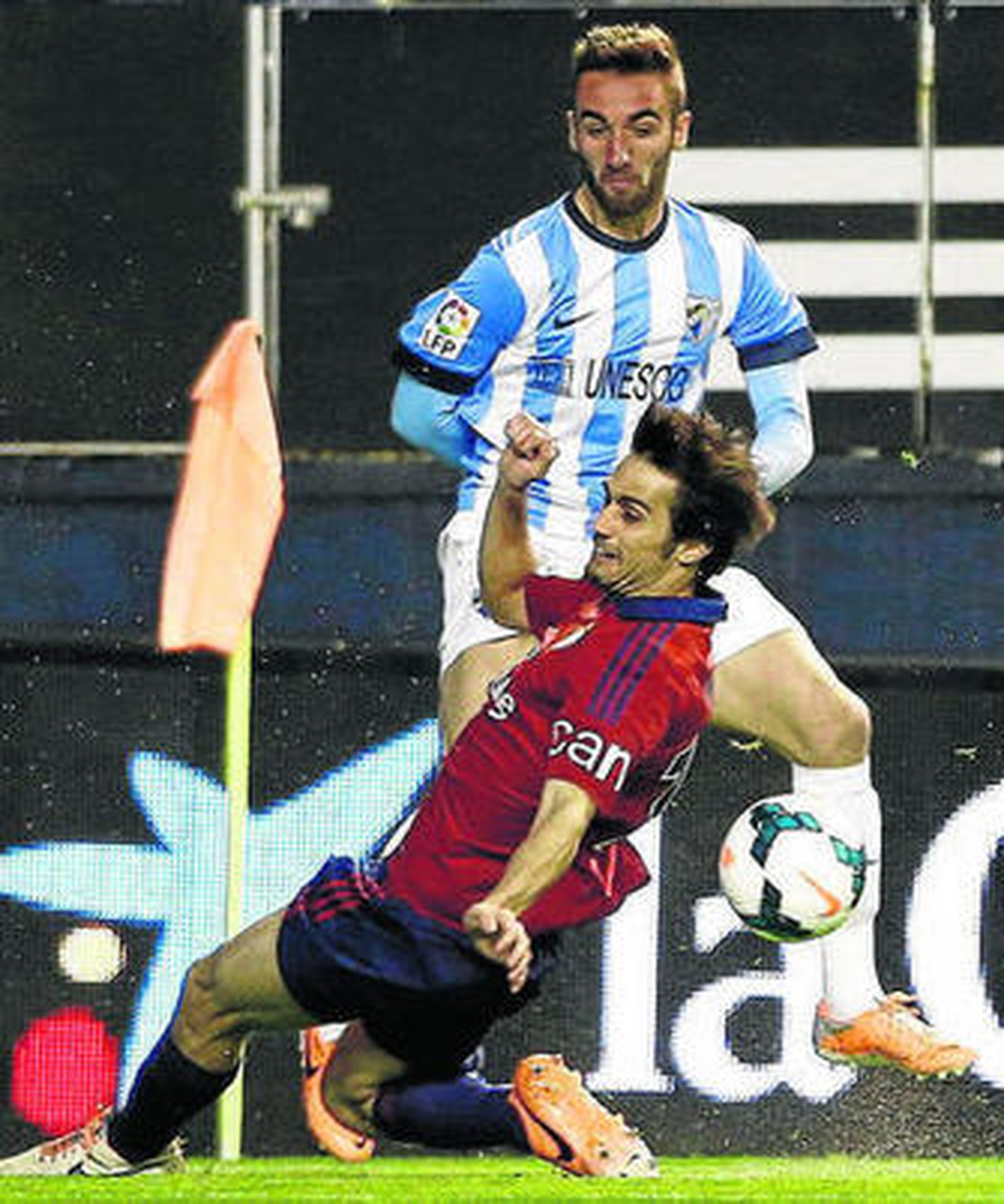 El malaguista Darder intenta centrar ante el osasunista Arribas.