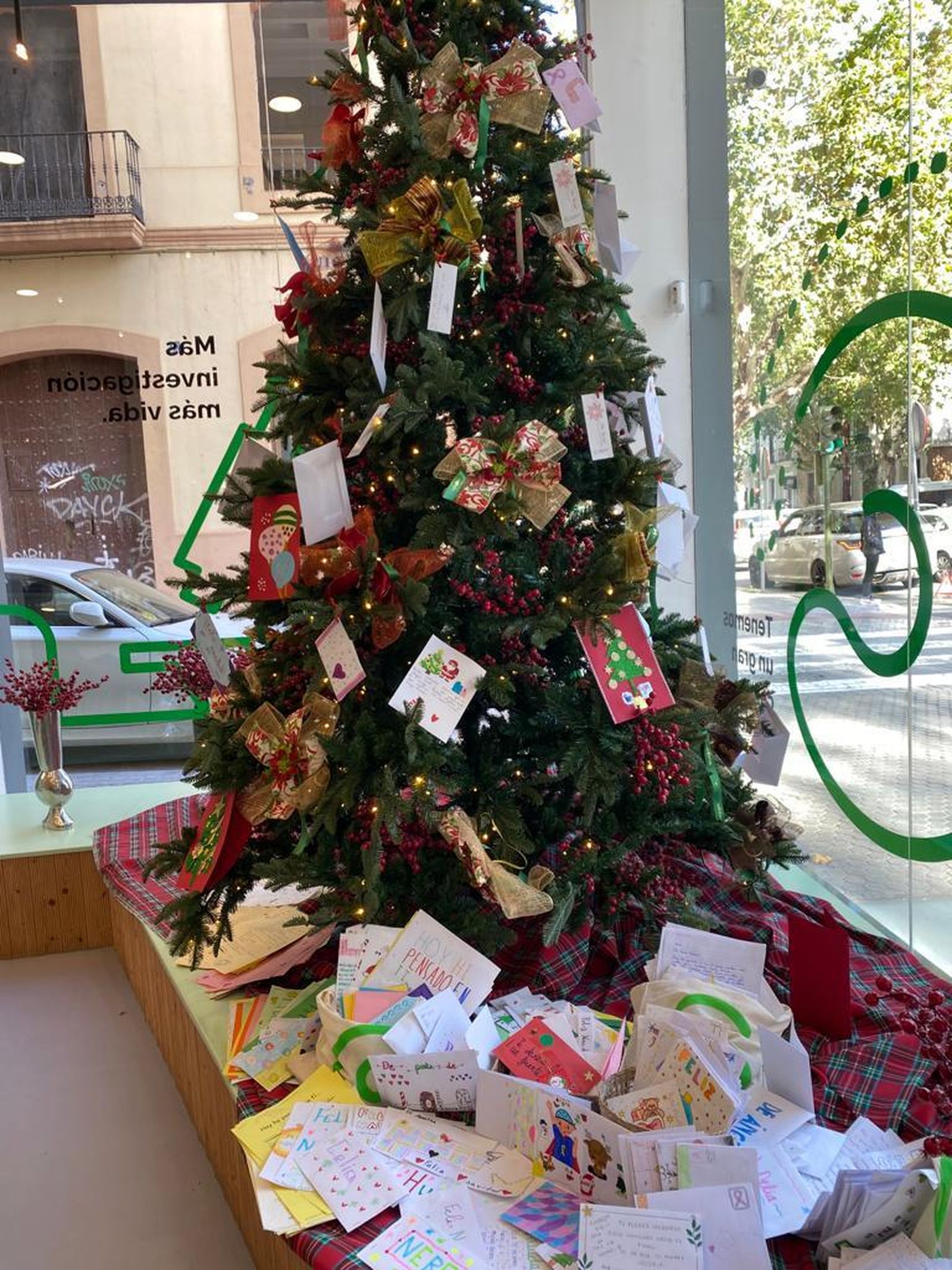 Un árbol de Navidad adornado con copias de las cartas que se enviarán a los hospitales