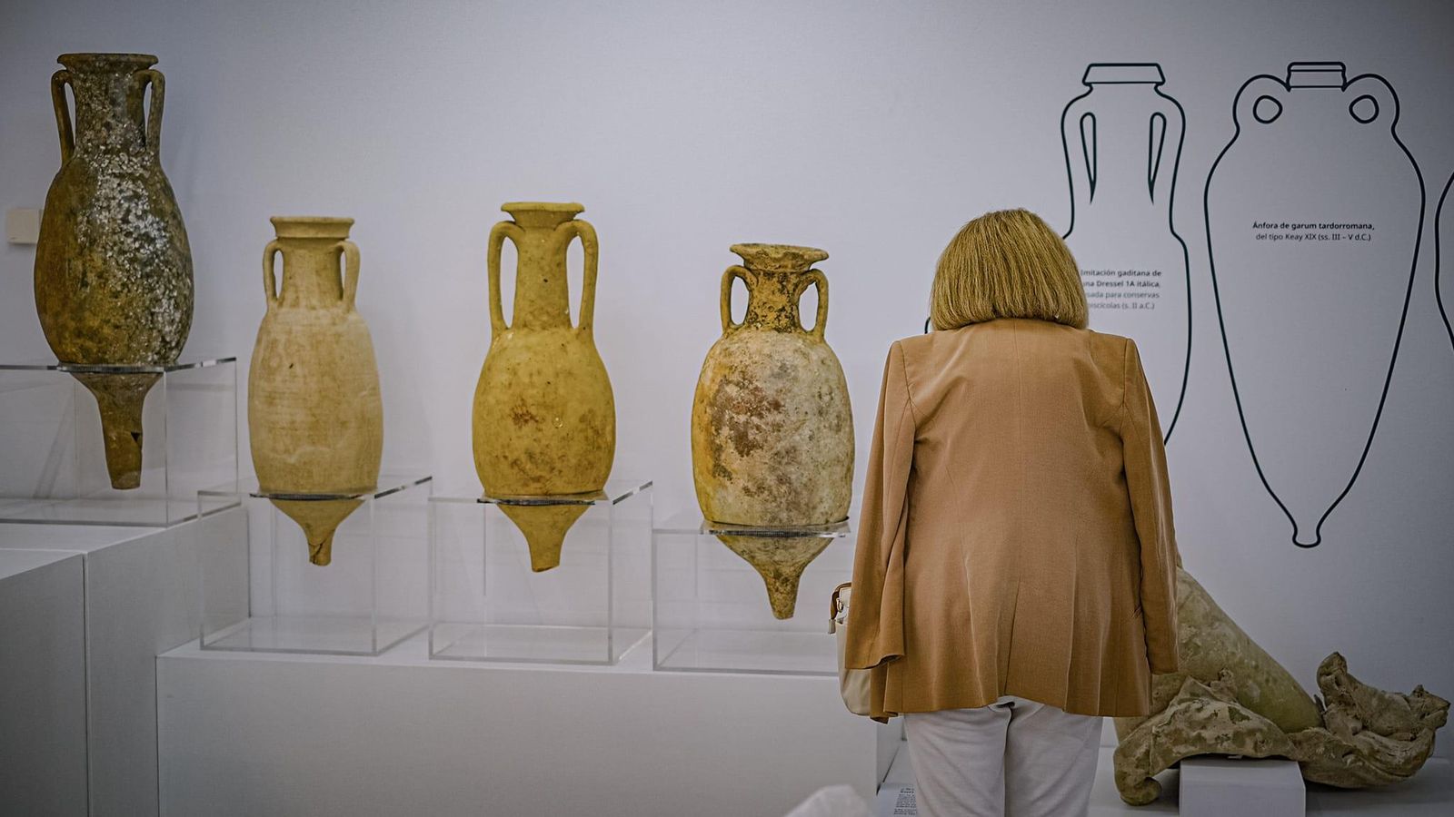 Una mujer observa las ánforas romanas que se exponen en Casa Pinillos