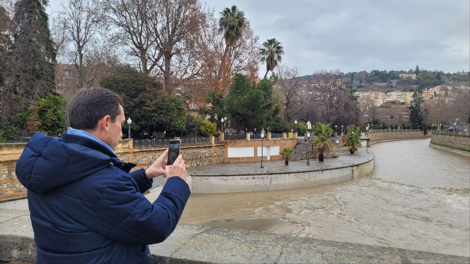 Imagen de un hombre fotografiando el río Genil, en el Puente Romano de Granada