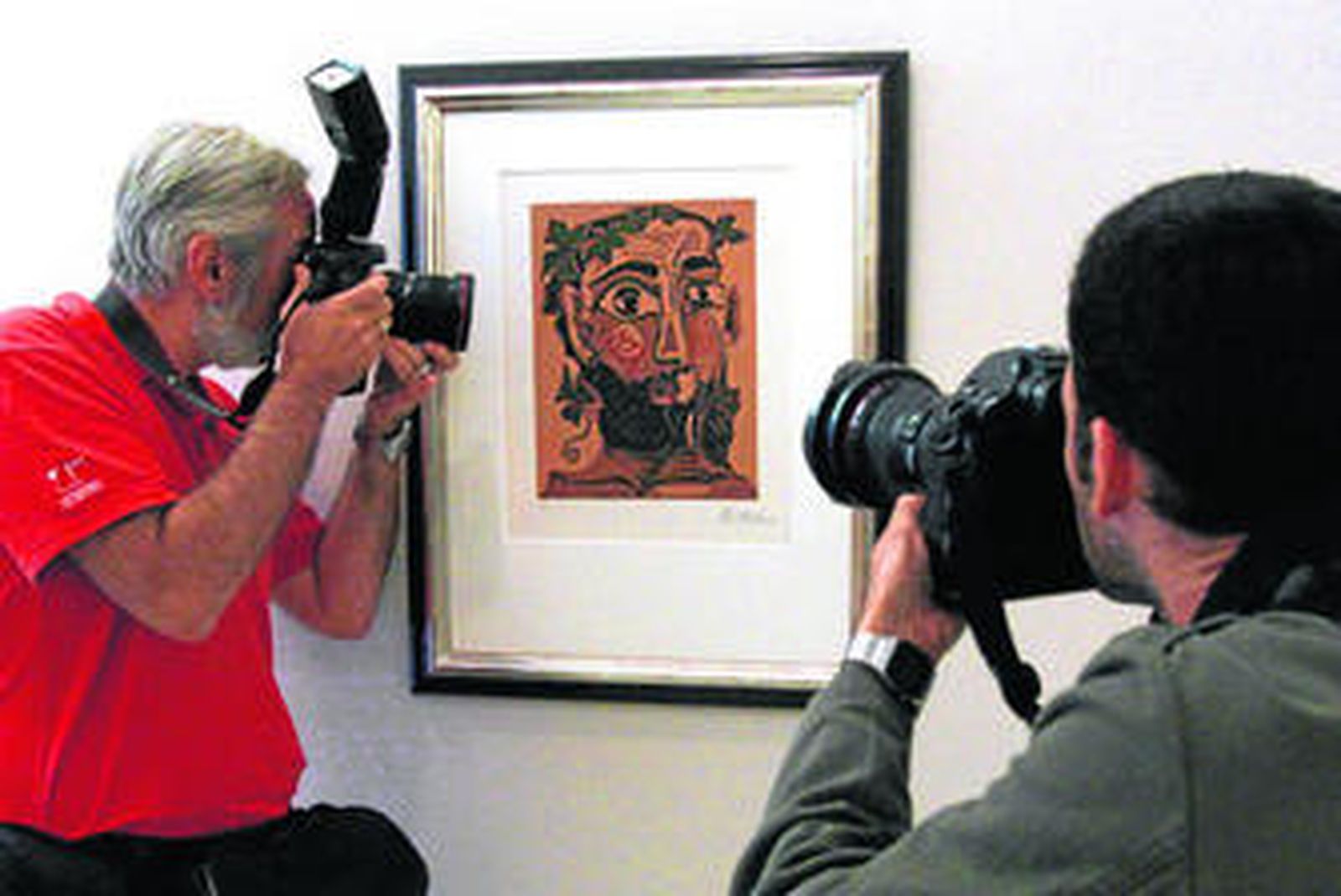 Dos fotógrafos de prensa retrataban ayer el grabado 'Hombre barbudo coronado de pámpanos', adquirido por la Fundación Picasso.