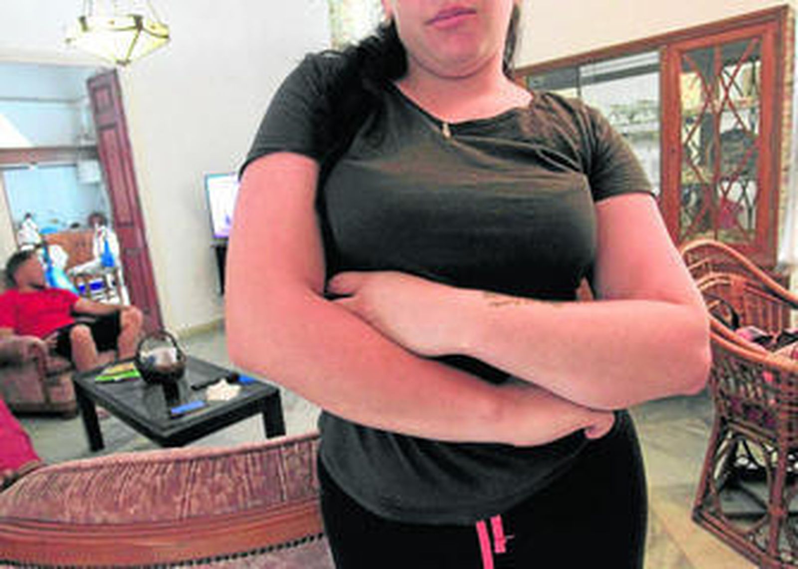 Vanesa Lara oculta su rostro, en su vivienda. Al fondo, su pareja.