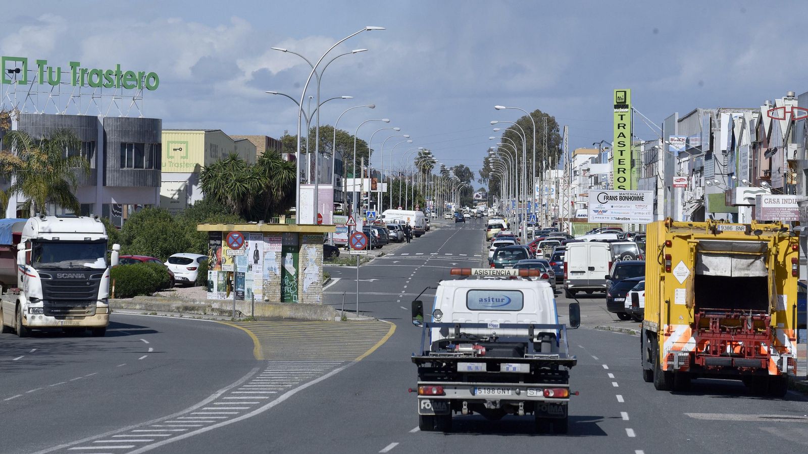 Una grúa y un camión de basura circulan por el Polígono Store.