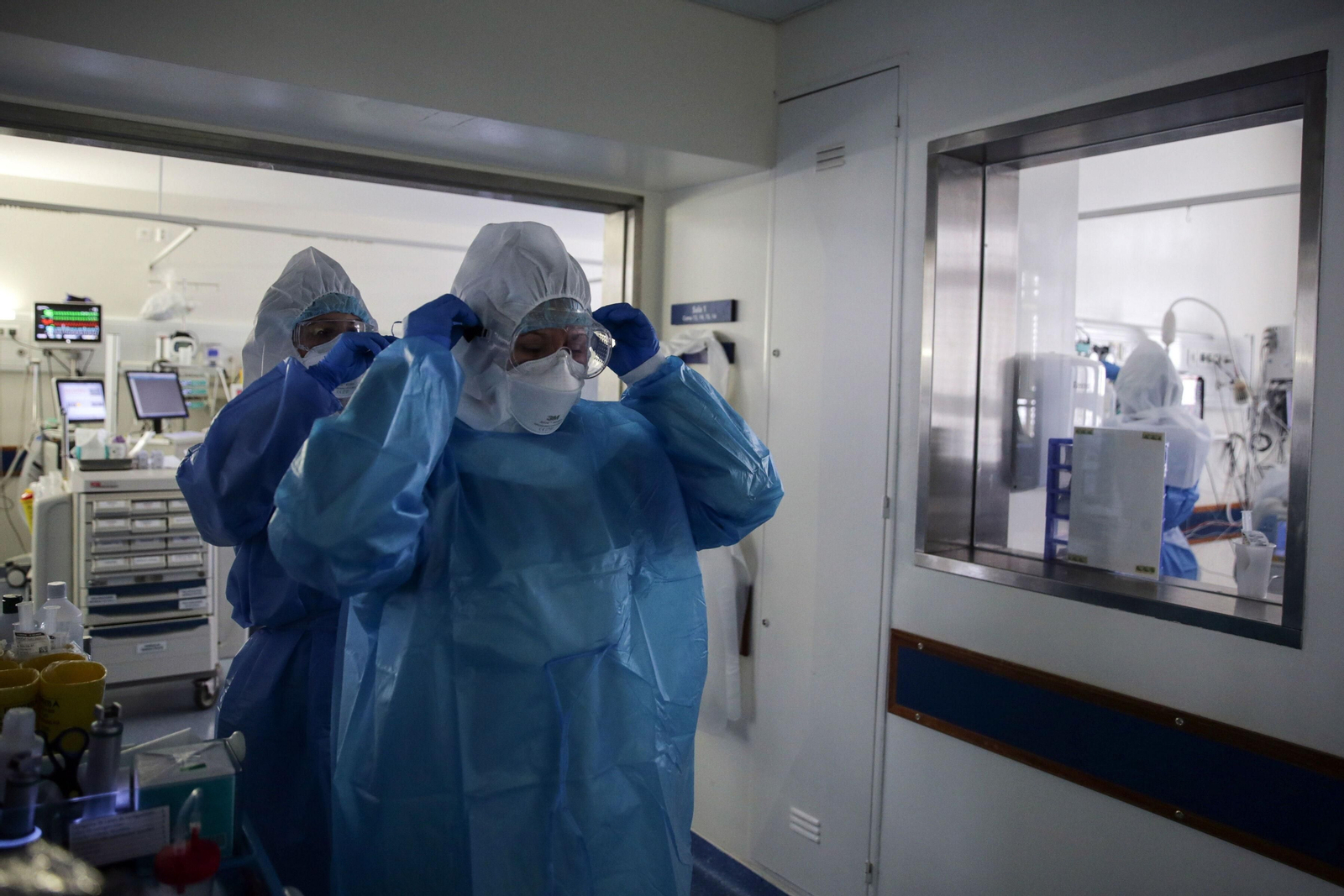 Dos profesionales sanitarios se preparan para entrar en una UCI.