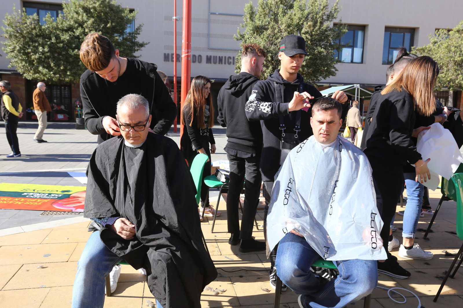 Estudiantes del centro educativo durante el corte de pelo a vecinos de la localidad.