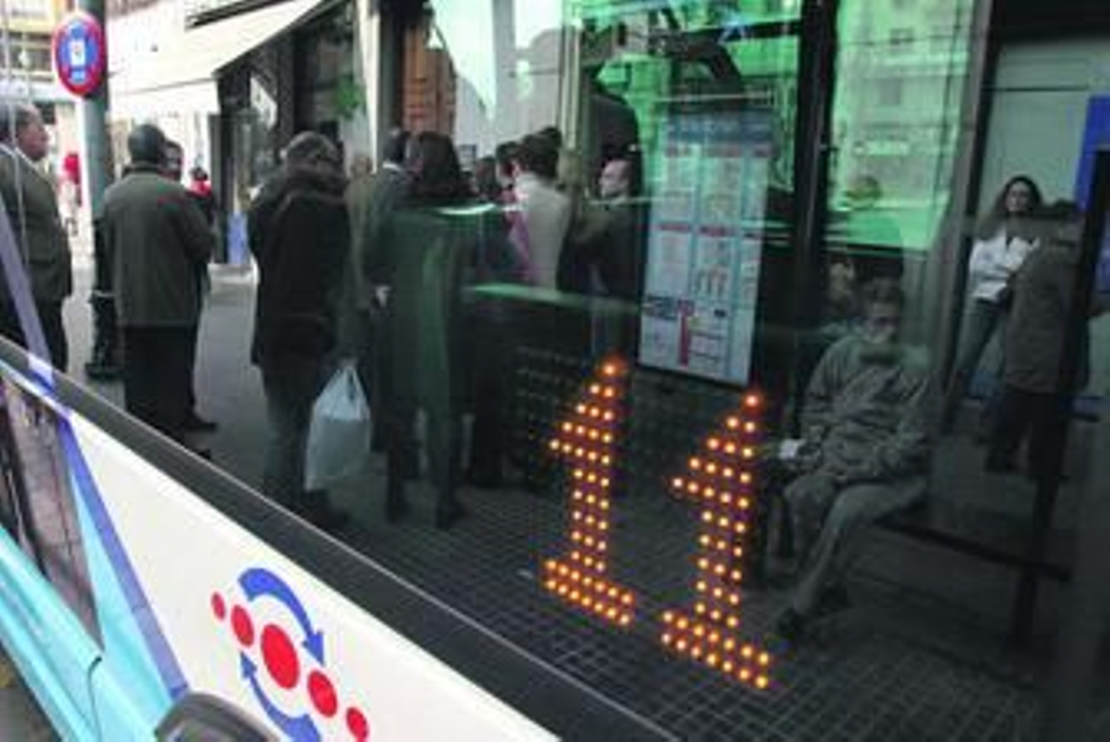 Pasajeros esperan para subirse al autobús de la línea 11.