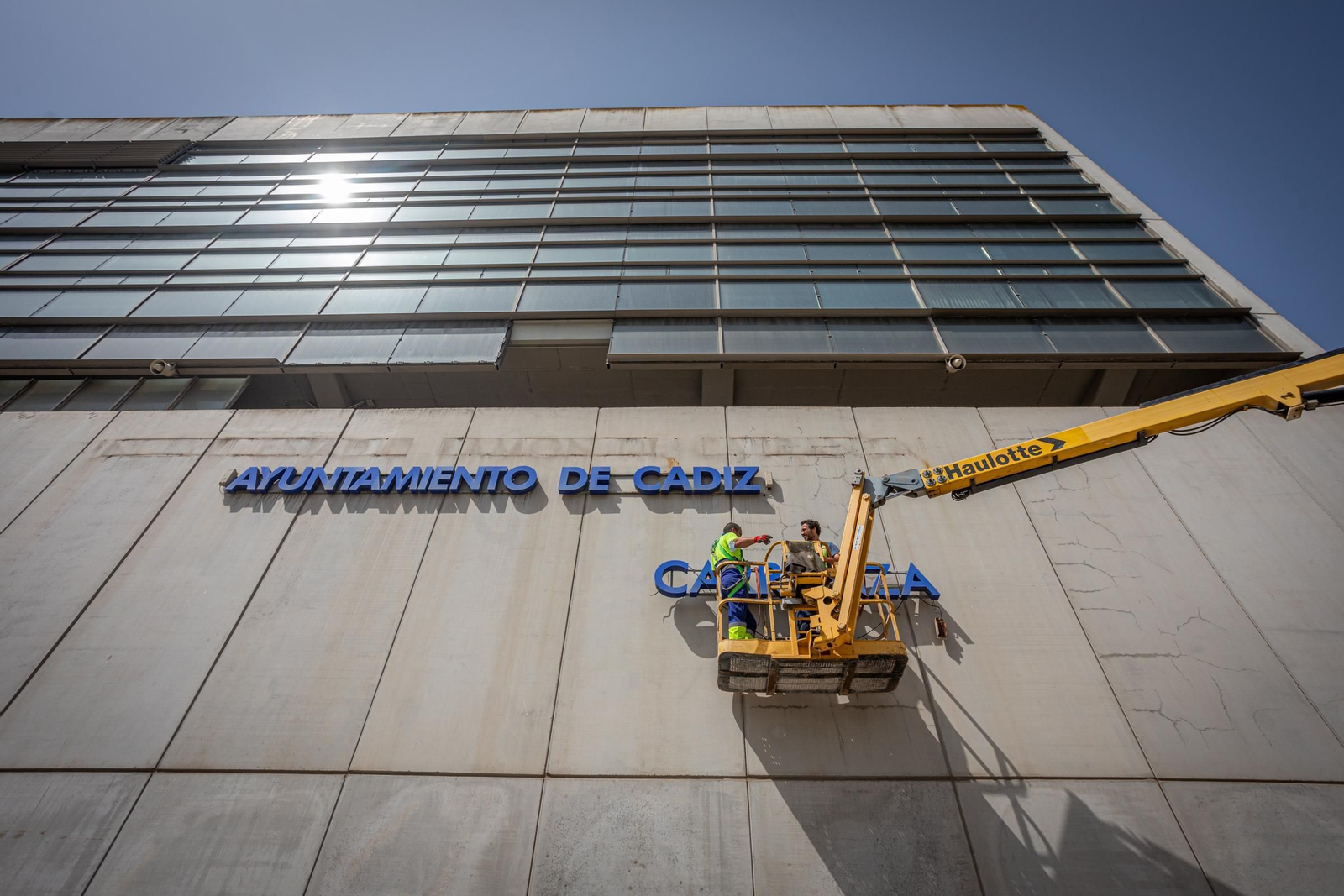 Operarios retiran los antiguos rótulos de Ramon de Carranza de la fachada del estadio.