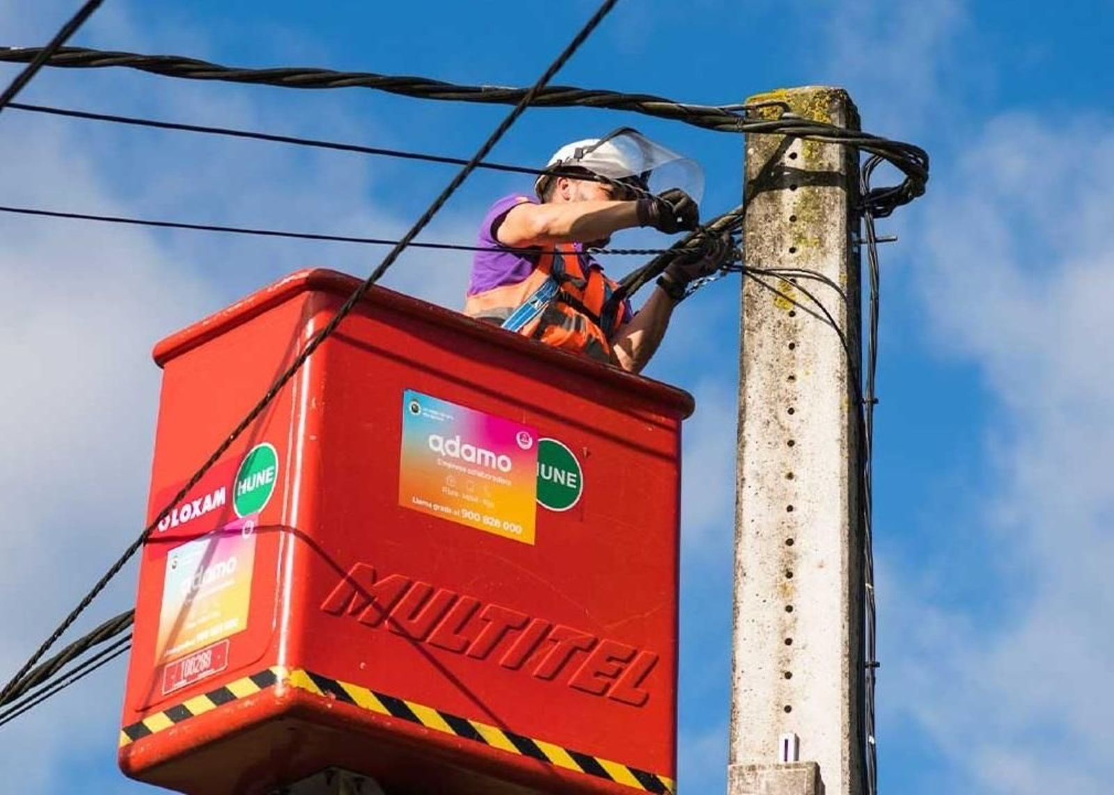 Un operario coloca cable de fibra óptica en un poste de luz