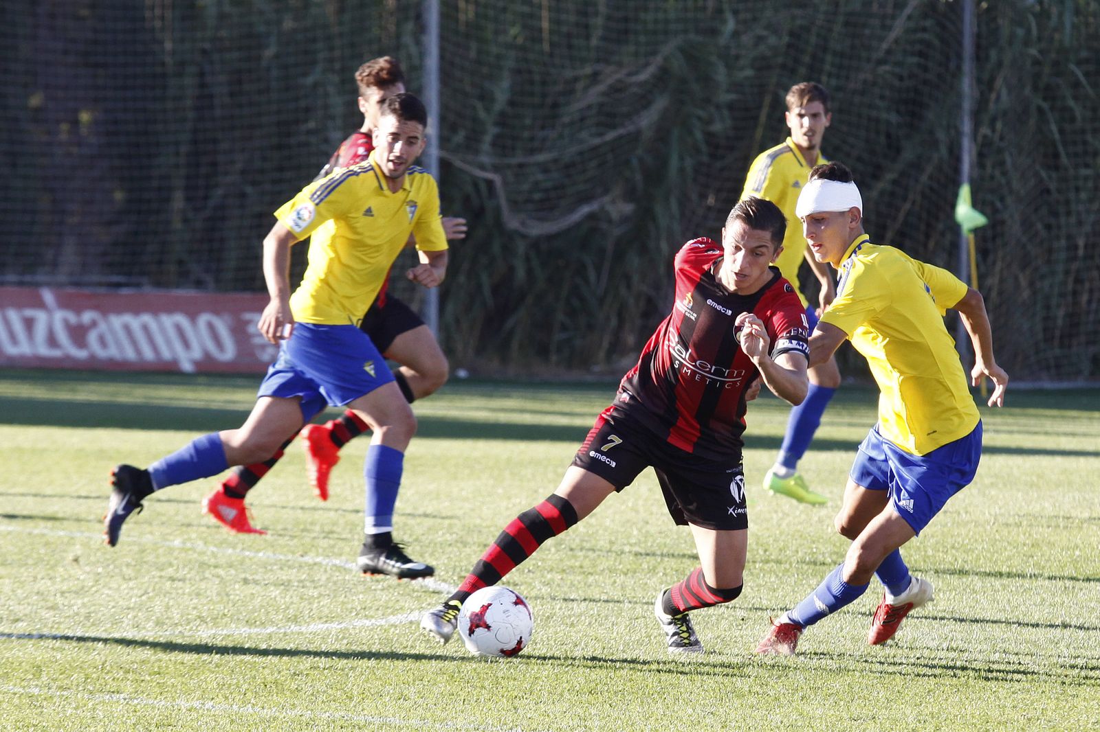 El rojinegro Carracedo trata de burlar la marca del lateral amarillo Cubero.