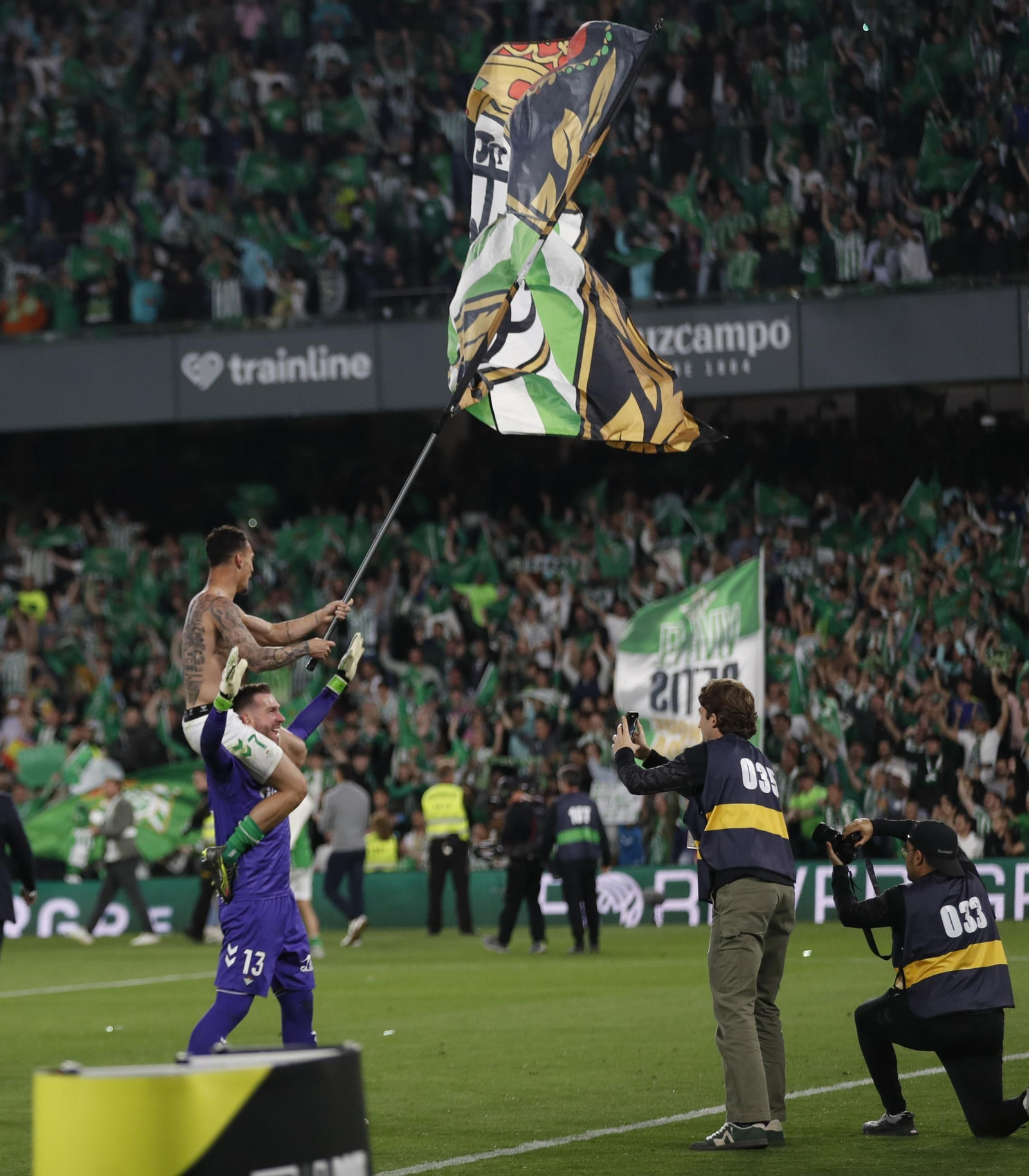 Antony enarbola la bandera del Betis a hombros de Adrián.