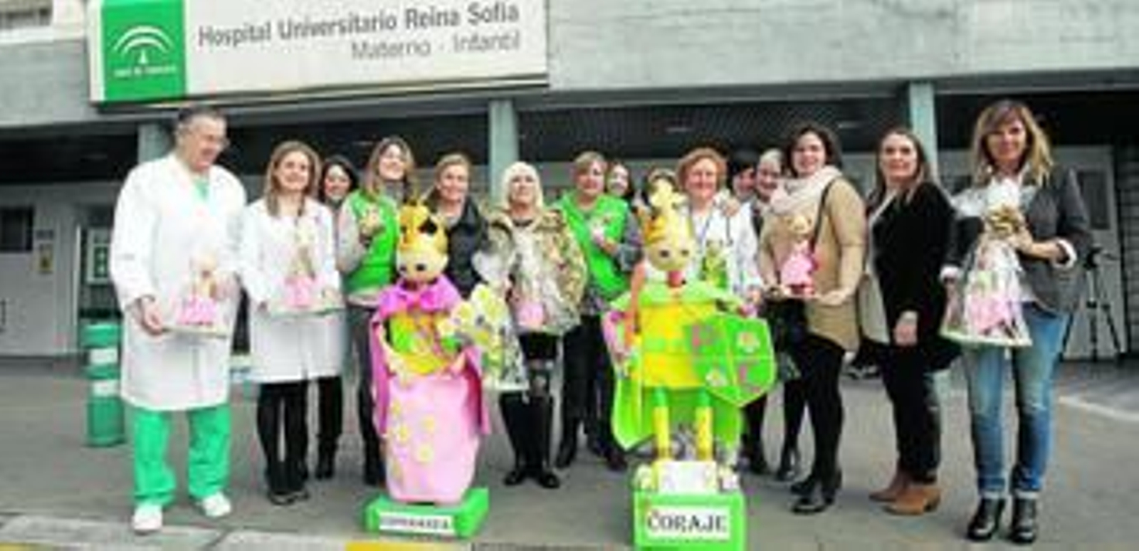 Voluntarias de la AECC y médicos del Reina Sofía, en la puerta del Hospital Infantil con los muñecos.