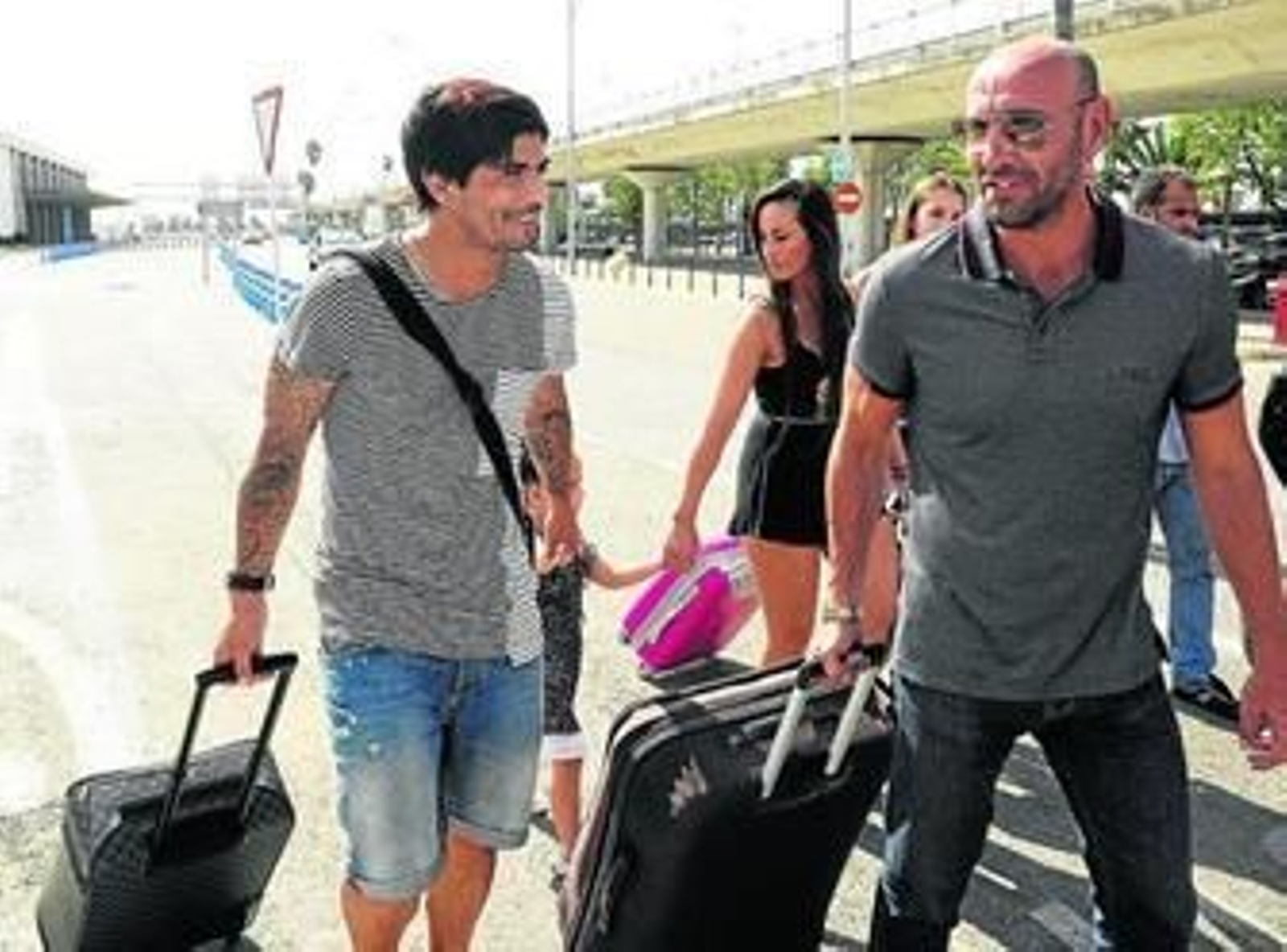 Monchi ayuda con el equipaje a Banega, que llegó con su familia ayer a Sevilla.