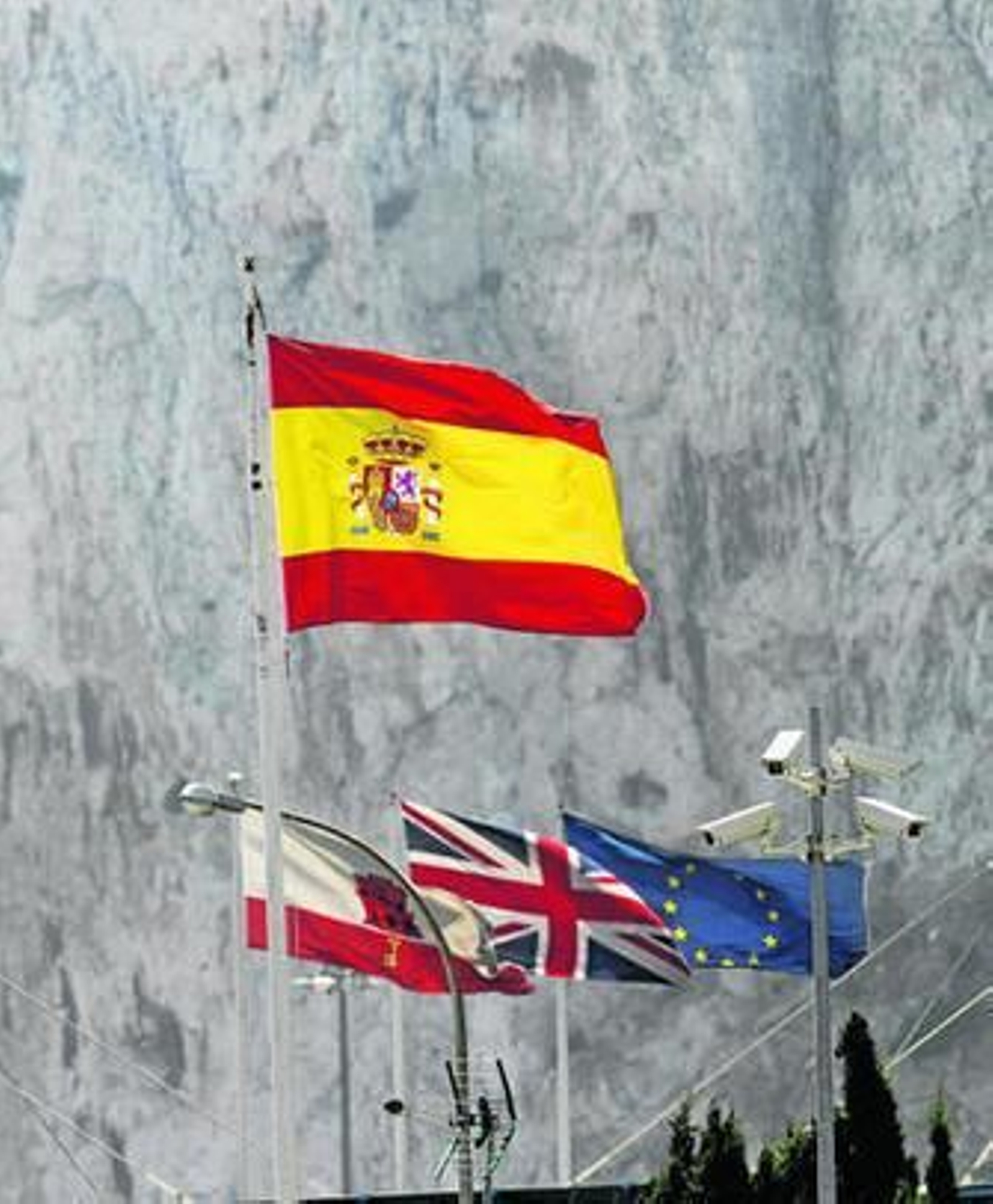 Las banderas de España, Gibraltar, el Reino Unido y Unión Europea con la mole del Peñón al fondo.