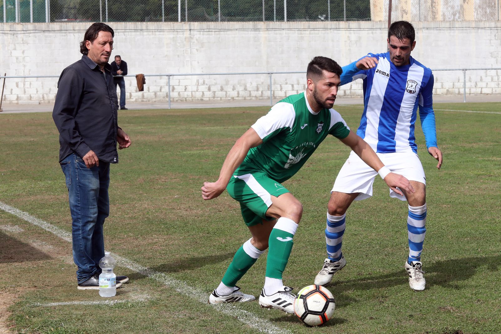 Manolo presiona a un rival ante la mirada de 'Pepichi' Torres, técnico del Villamartín.