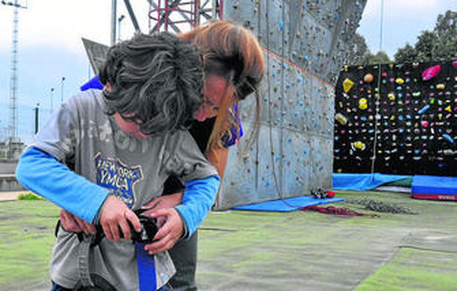 1. Una monitor ayuda a un pequeño a colocarse las correas de seguridad. 2. Un niño en plena ascensión. 3. Un monitor da indicaciones a los niños ante el rocódromo.