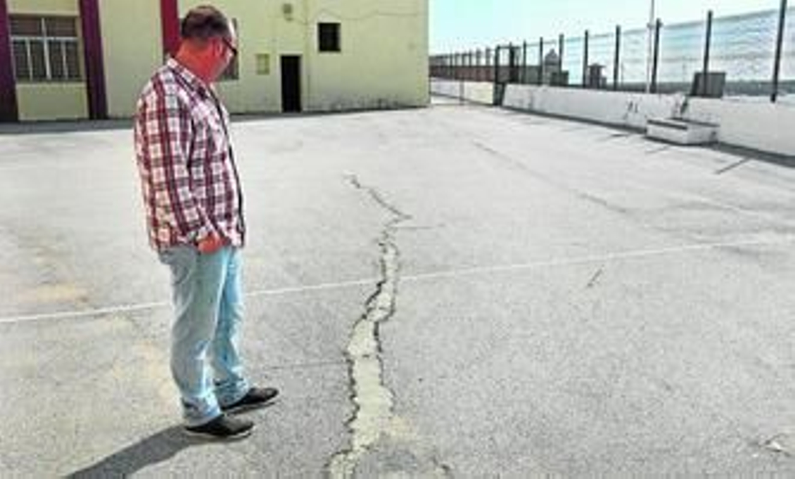 El director del centro, Emilio Bautista, señala las grietas que hay en el patio del CEIP Santa Teresa.