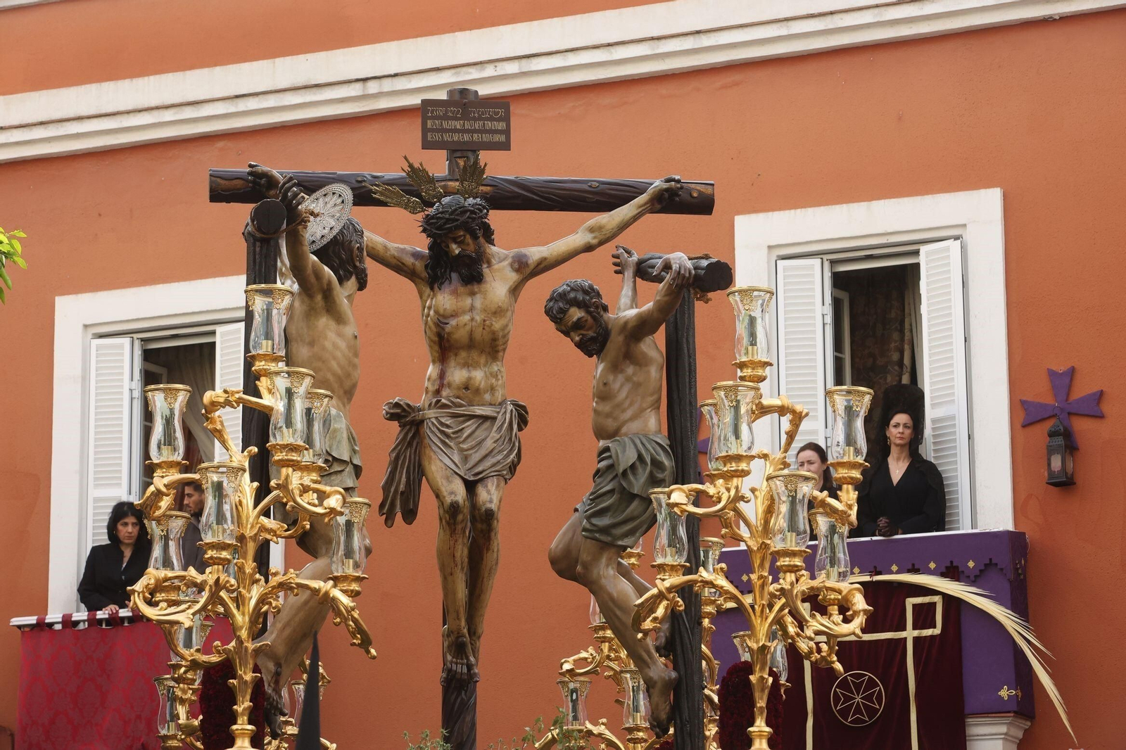 Una mujer de mantilla, ante el misterio  de la Vera Cruz.