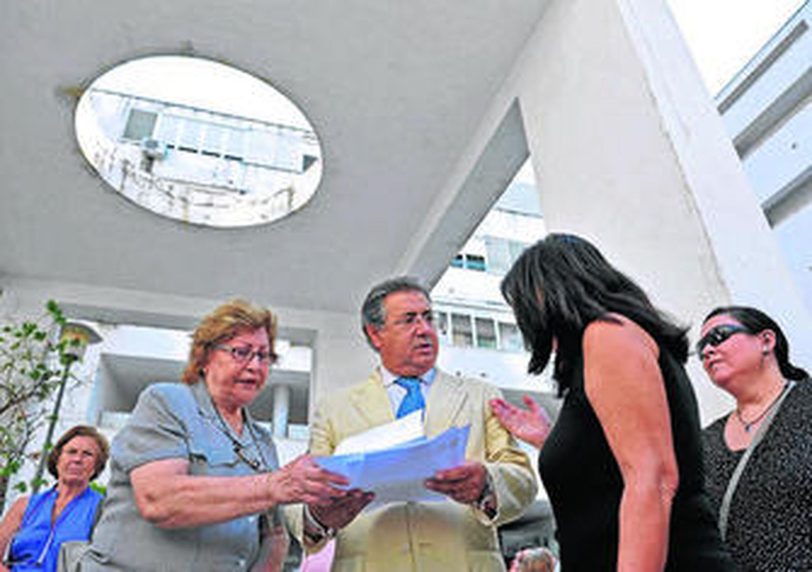 El alcalde sevillano revisa documentación de los vecinos de este bloque de viviendas sociales de Nervión.