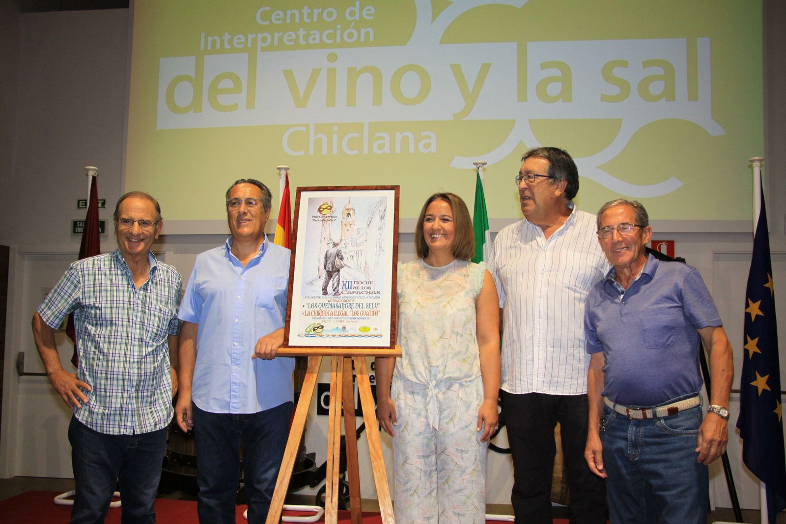 La edil Ana González con miembros de la Peña Perico Alcántara y José Antonio Barberá (segundo por la izquierda) junto al cartel del evento.