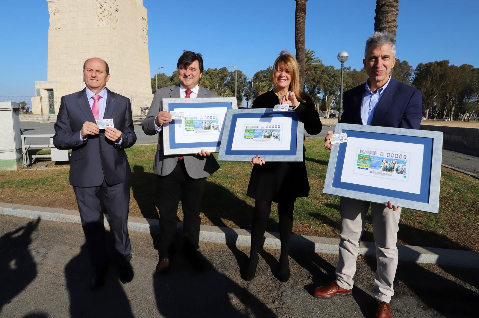 Nicolás Vargas, Gabriel Cruz y Pilar Miranda, posando con el cupón ante el Monumento.