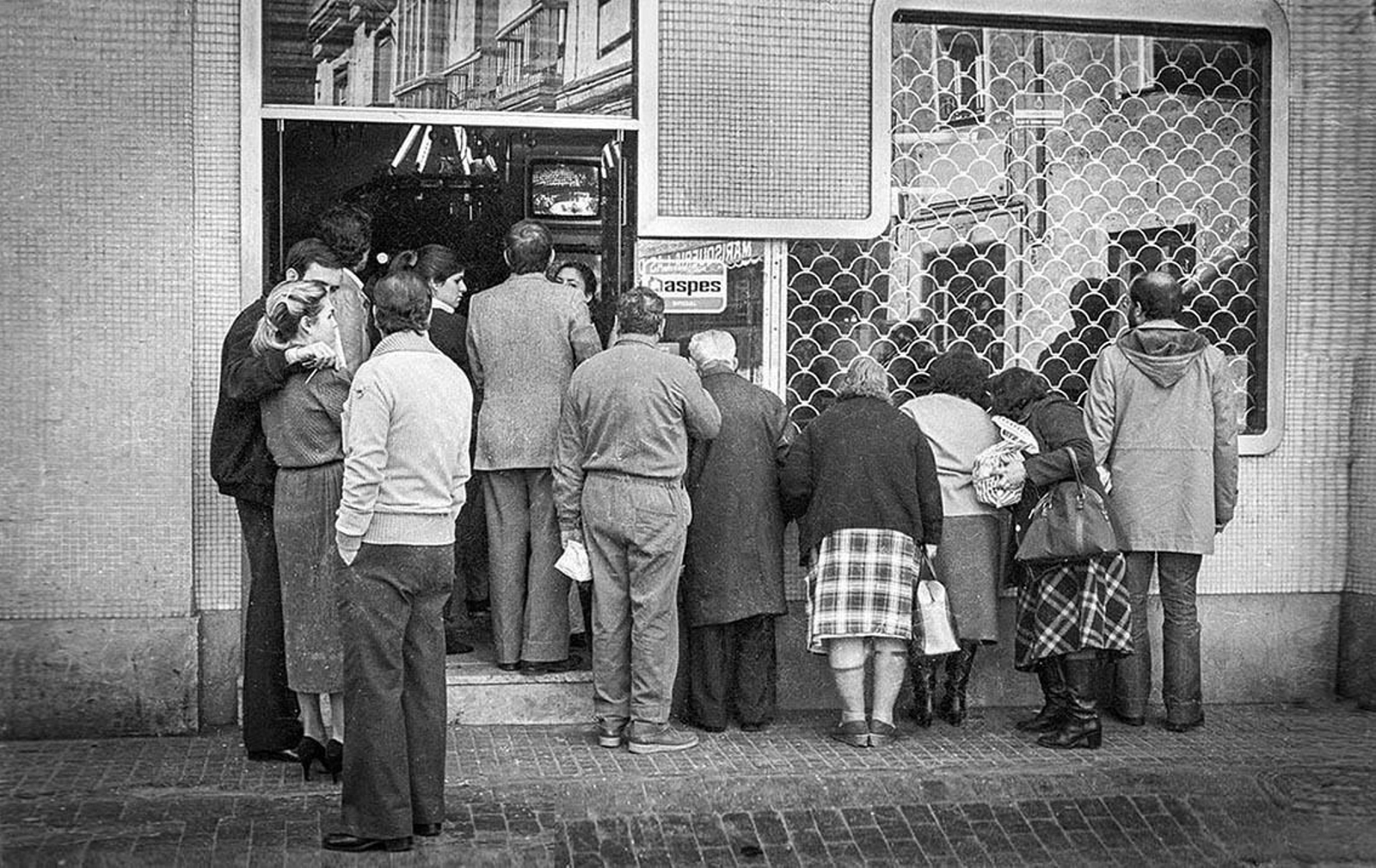 Varias personas se agolpan en un comercio de la plaza de San Agustín, en Cádiz, para seguir los últimos acontecimientos políticos en España, en una imagen del 24 de febrero de 1981, el día siguiente al intento de golpe de Estado.