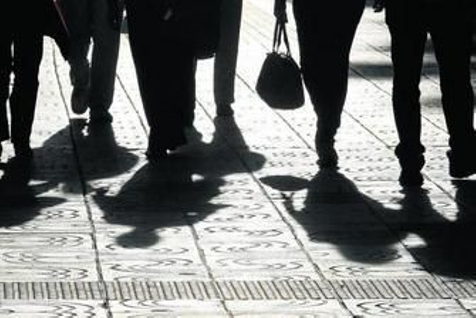 La silueta de varias personas por una calle de Málaga.