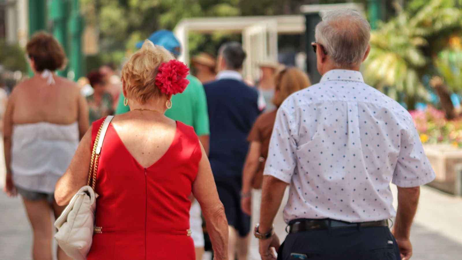 Dos personas mayores paseando por la Feria Dos personas mayores paseando por la Feria