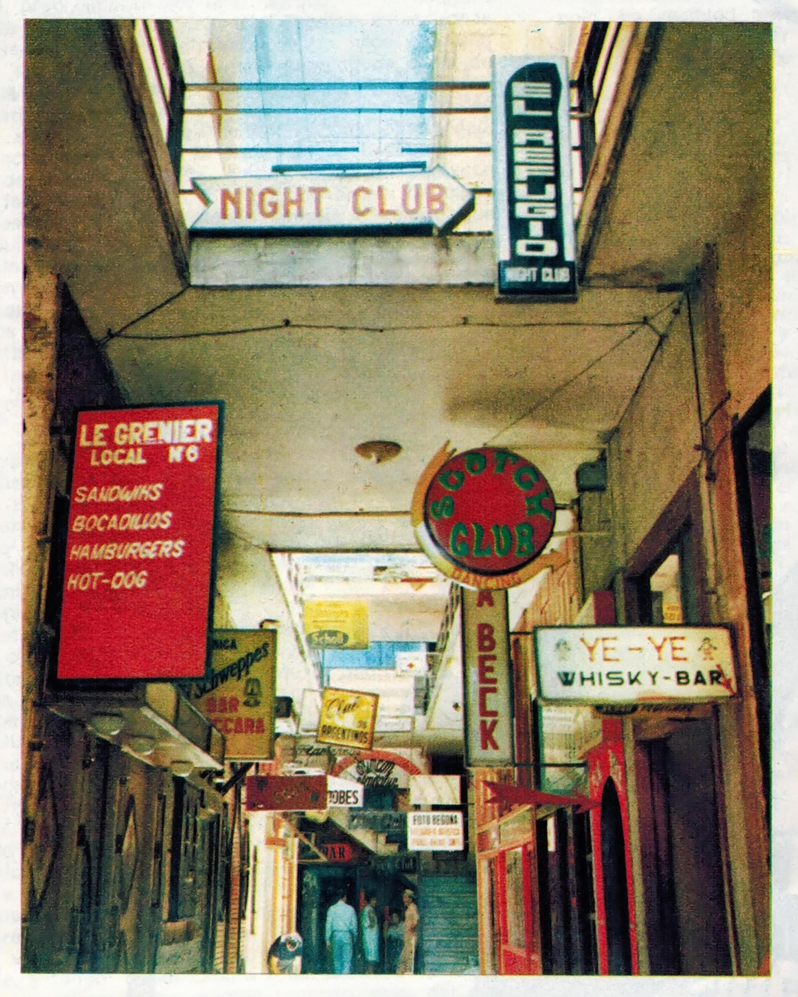 Postal del Pasaje Begoña en los años 60, con numerosos carteles de los diferentes locales.