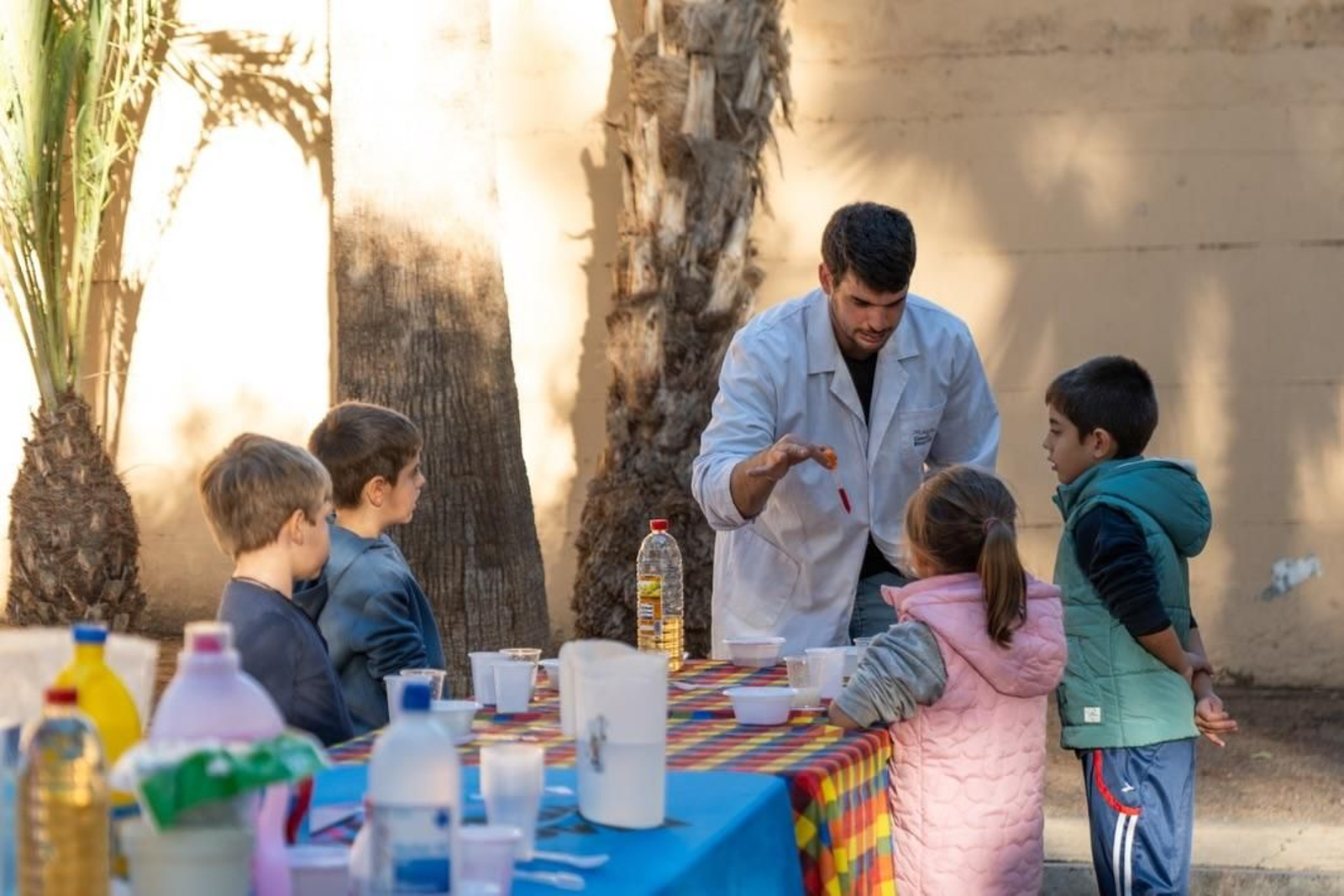Un monitor de 'Ciencia Park' explica a niños y niñas un taller de ciencia.