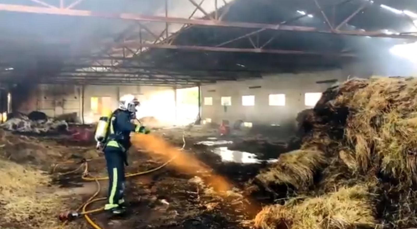 Un bombero extingue el fuego en una nave agrícola de Fontanar de Quintos.