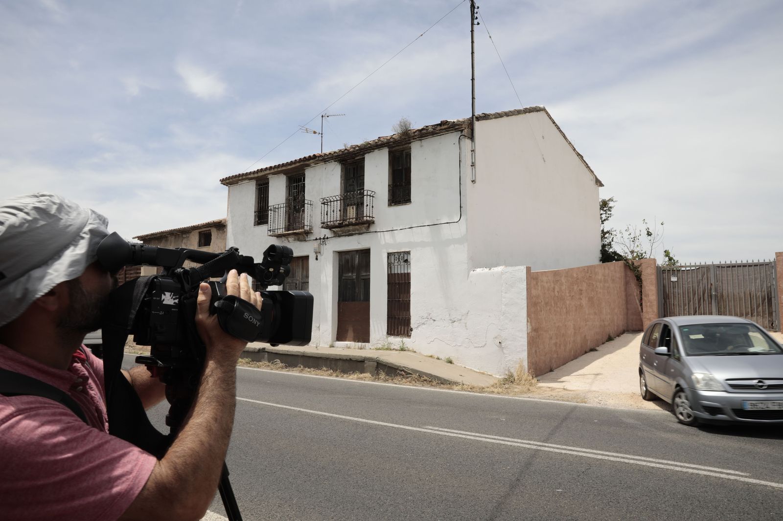 Un cámara y un fotógrafo toman imágenes de la vivienda en la que se localizó el cuerpo en Alcira.