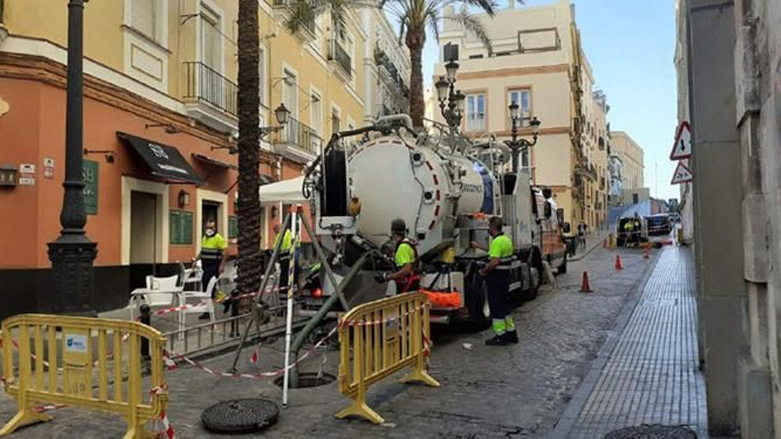 Varios operarios limpian la red de saneamiento en Cádiz.