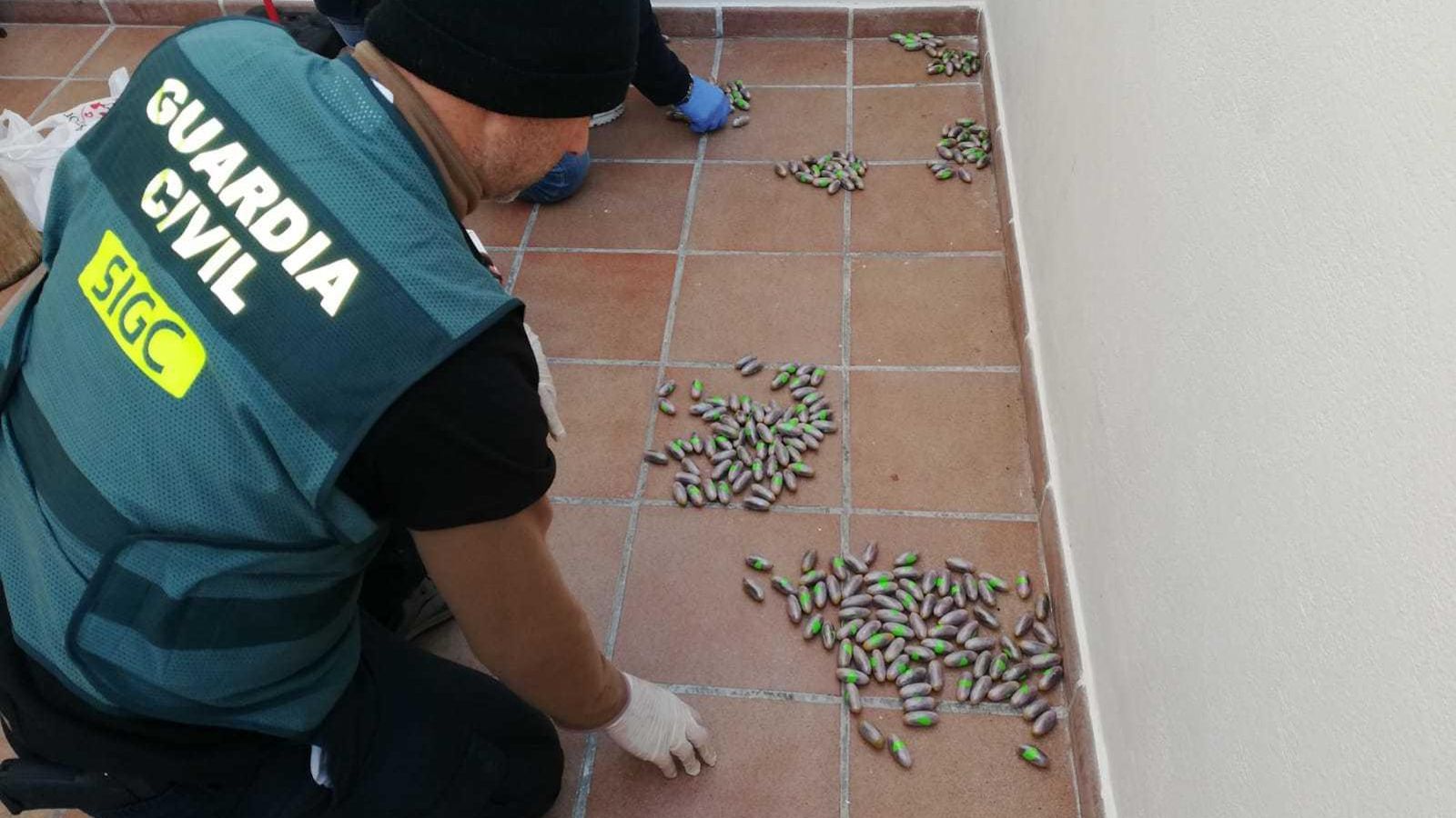 La Guardia Civil recogiendo algunas de las bellotas de hachís encontradas.
