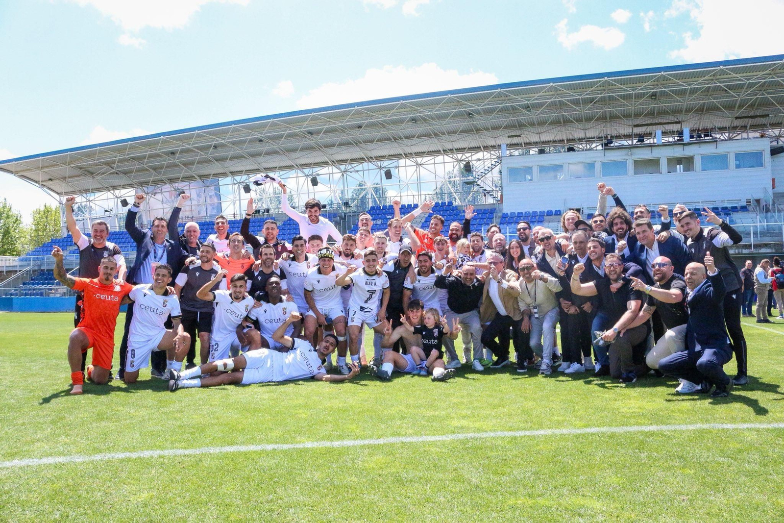 Los integrantes de la expedición ceutí a tierras madrileñas celebran su ascenso sobre el terreno de juego del Estadio Fernando Torres.