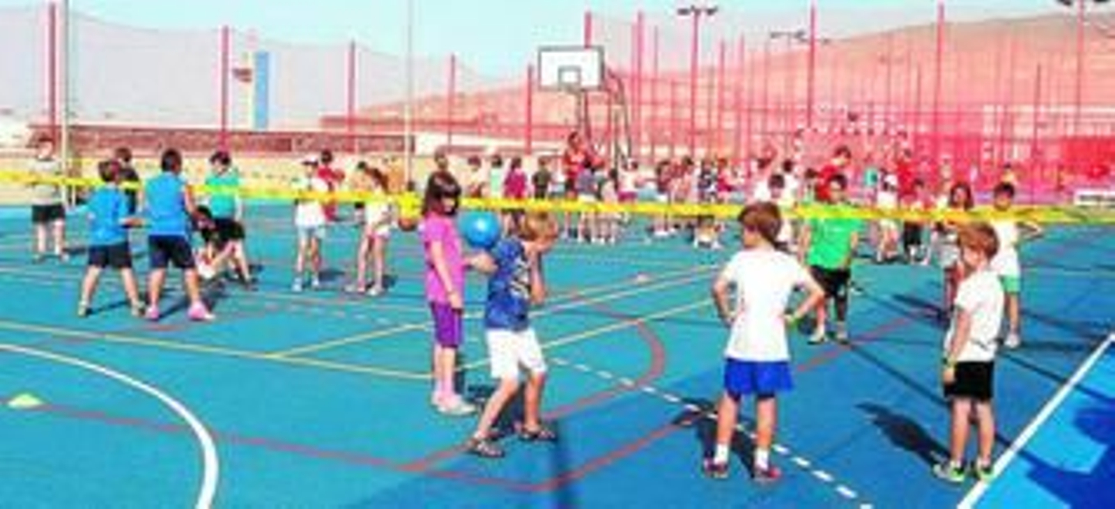 Diferentes grupos de niños jugando en las pistas polideportivas del Ego.