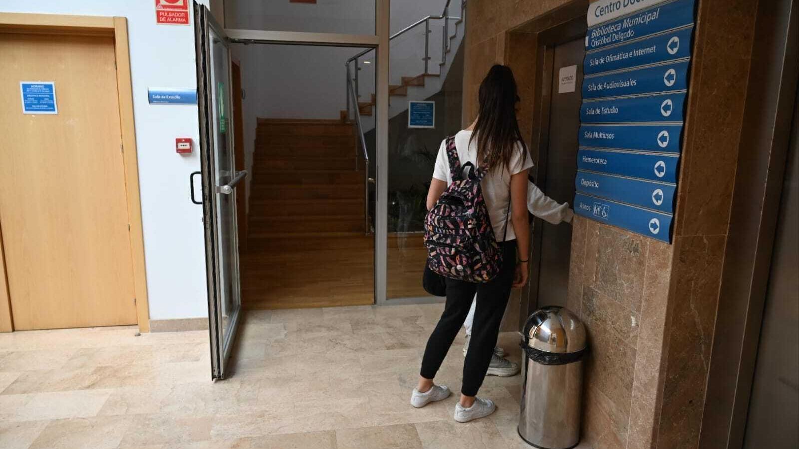 Dos jóvenes intentan subir a la biblioteca a través del ascensor, este lunes.