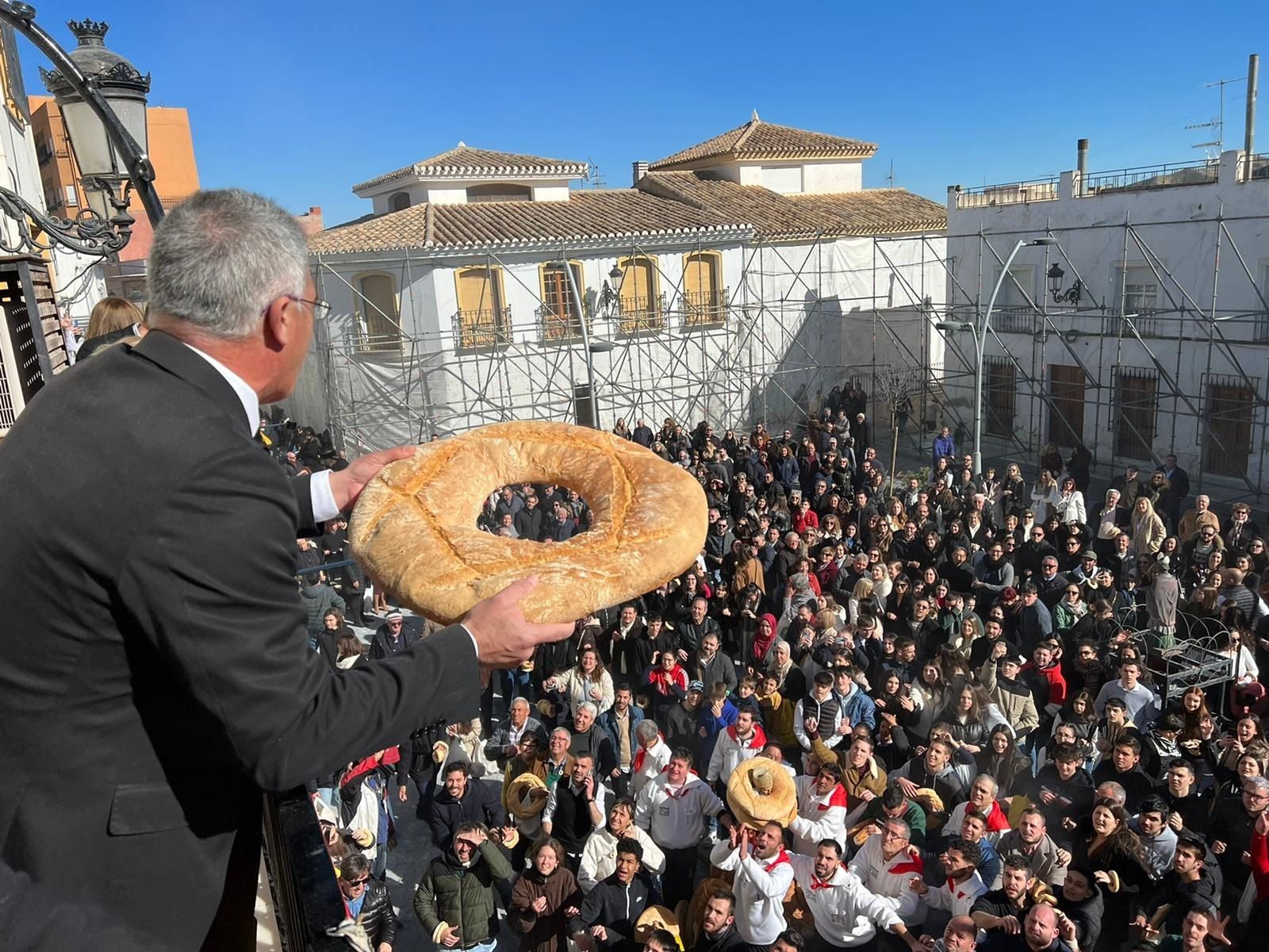 El alcalde, Antonio Martínez, lanza roscos desde el balcón del Ayuntamiento.