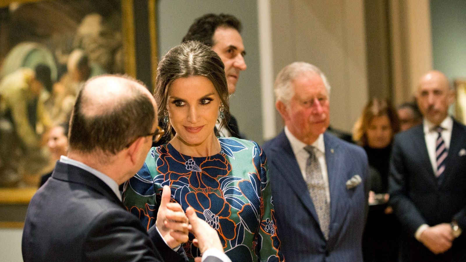 La Reina, conversando con uno de los comisarios de la muestra, y Carlos de Inglaterra en segundo plano.