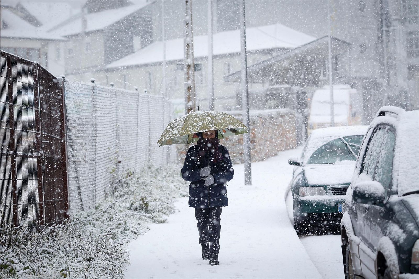 Una señora bajo la nieve en Galicia.