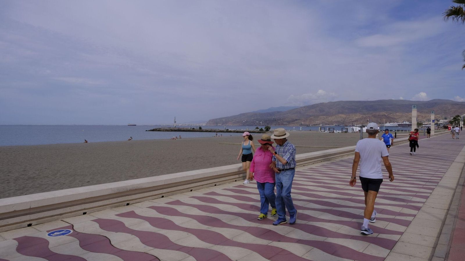 Varias personas caminando en el Paseo Marítimo de Almería.