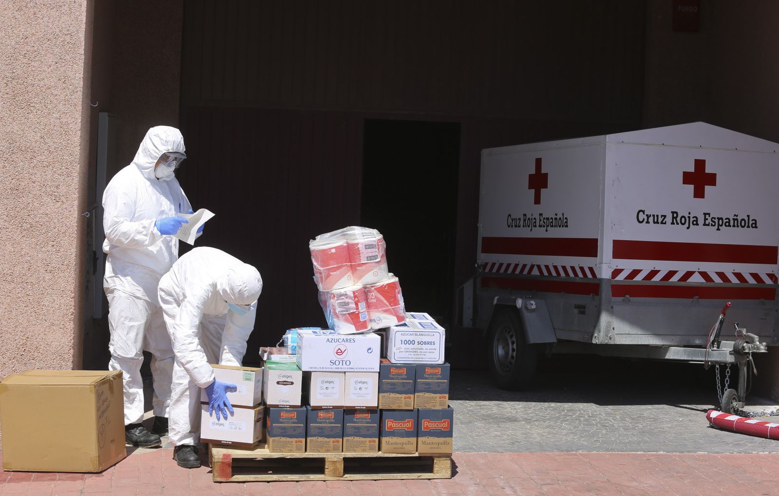 Personal de Cruz Roja, con los equipos de protección, en el centro de Ortega y Gasset.